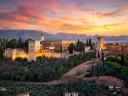 The iconic Alhambra Palace hilltop illuminated at sunset in Granada